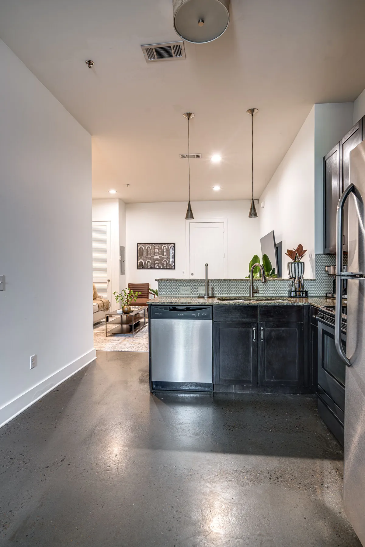 A modern kitchen with a spacious island, stainless steel appliances, and stylish cabinetry. Decorative artwork adds a personal touch, and the space is set up for cooking, entertaining, or gathering with friends and family.