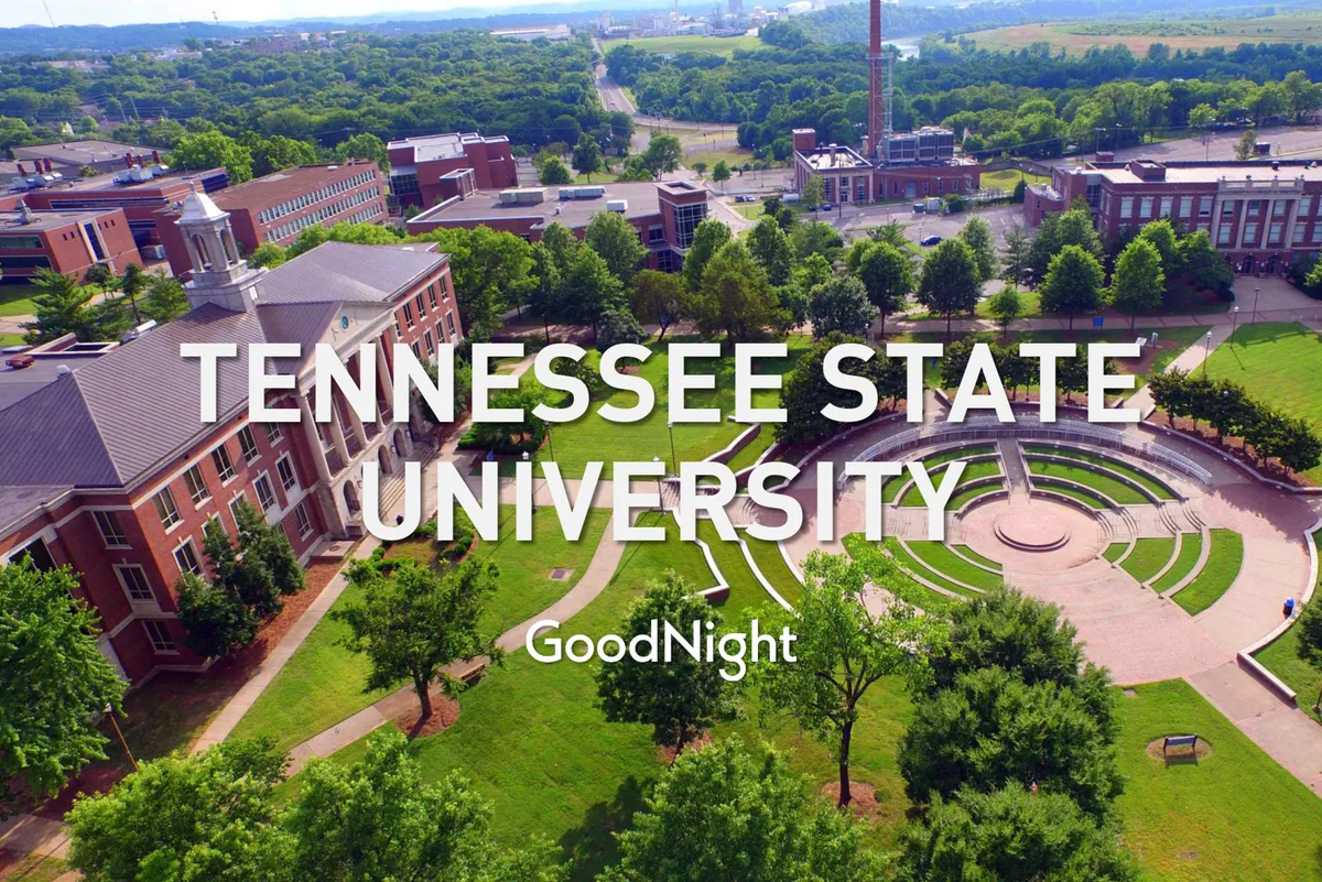An exterior view of Tennessee State University’s distinctive campus buildings, centered around a circular plaza and surrounded by lush, green lawns. Students can be seen walking and studying outdoors, highlighting an active, academic environment.