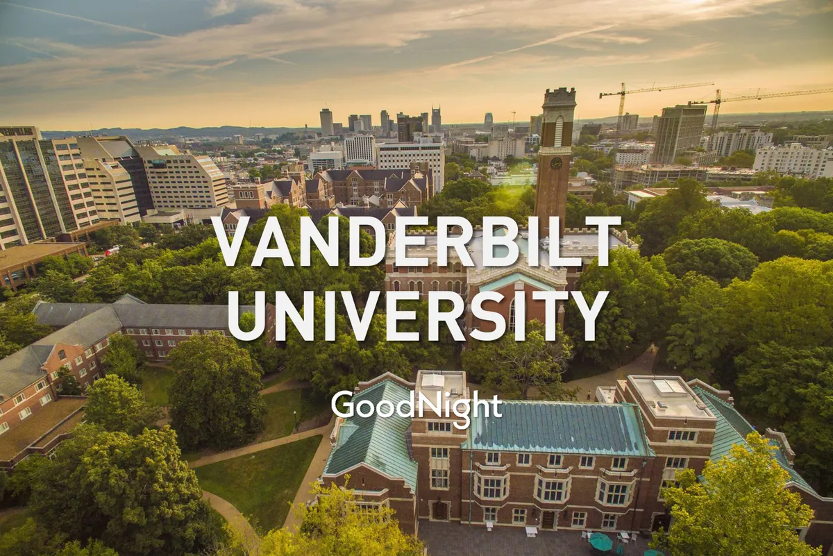 A sweeping view of Vanderbilt University’s iconic clock tower framed by leafy trees, with the Nashville city skyline visible in the background. The scene is tranquil, academic, and distinctly urban, capturing both the university environment and its proximity to city life.