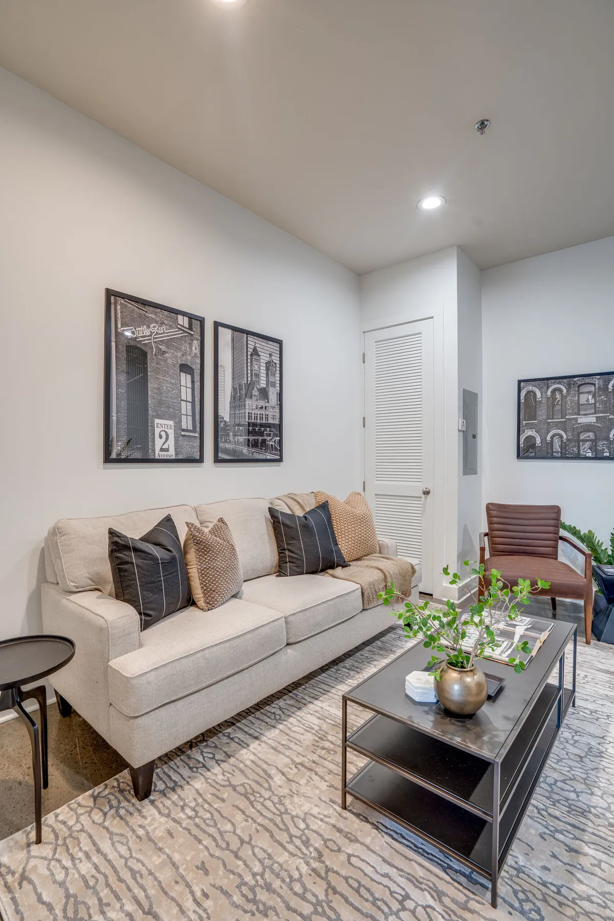 The image showcases a cozy living space with a stylish sofa, a modern coffee table, vibrant wall art, and lush green plants—all bathed in soft, natural light. The arrangement invites relaxation, intimate conversation, and creativity, with thoughtful design touches that blend comfort and sophistication.