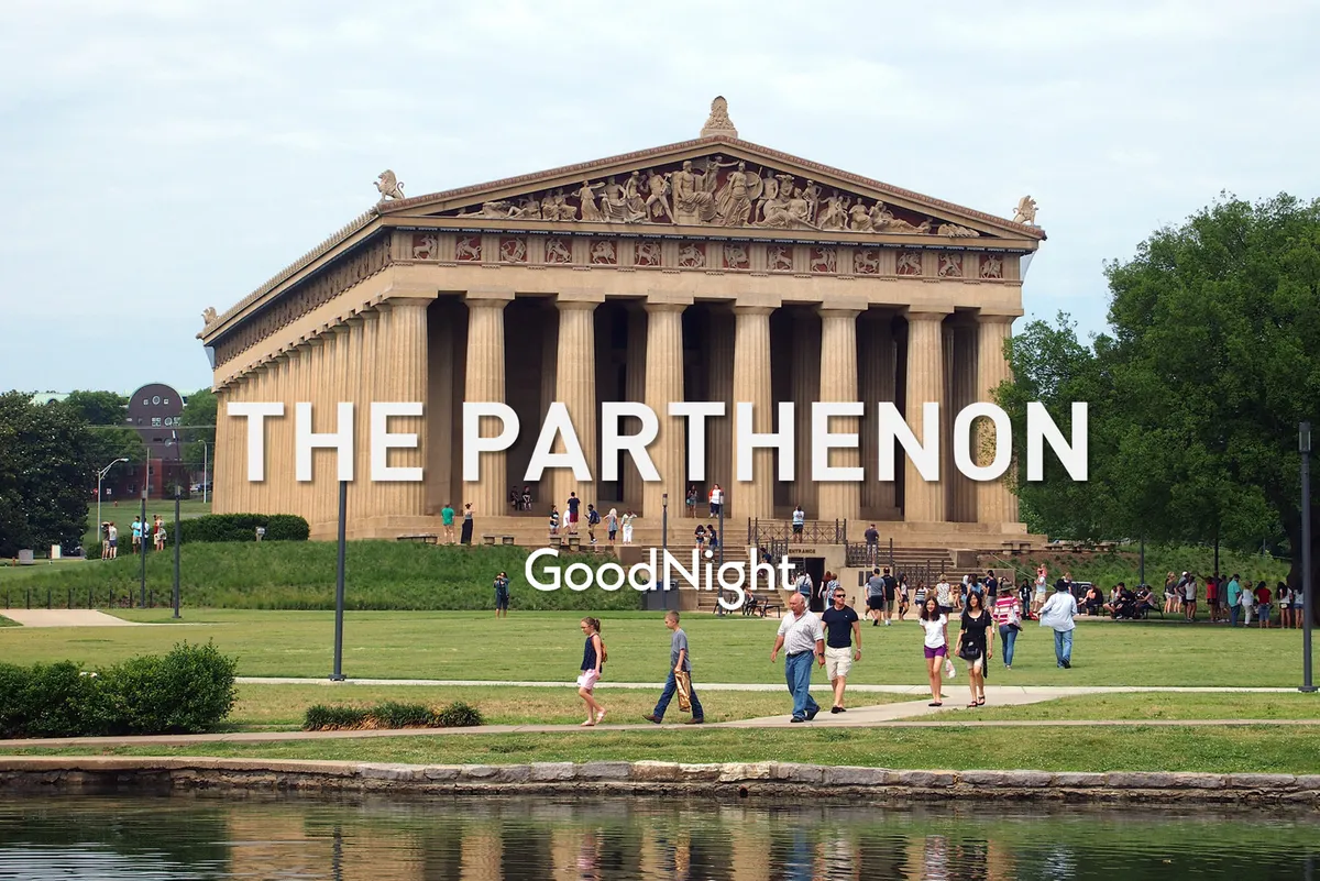 The Parthenon replica sits grandly in the middle of Centennial Park, surrounded by lush green lawns and reflective water. Visitors are seen strolling and taking photos, while the sunny weather adds to the inviting atmosphere.
